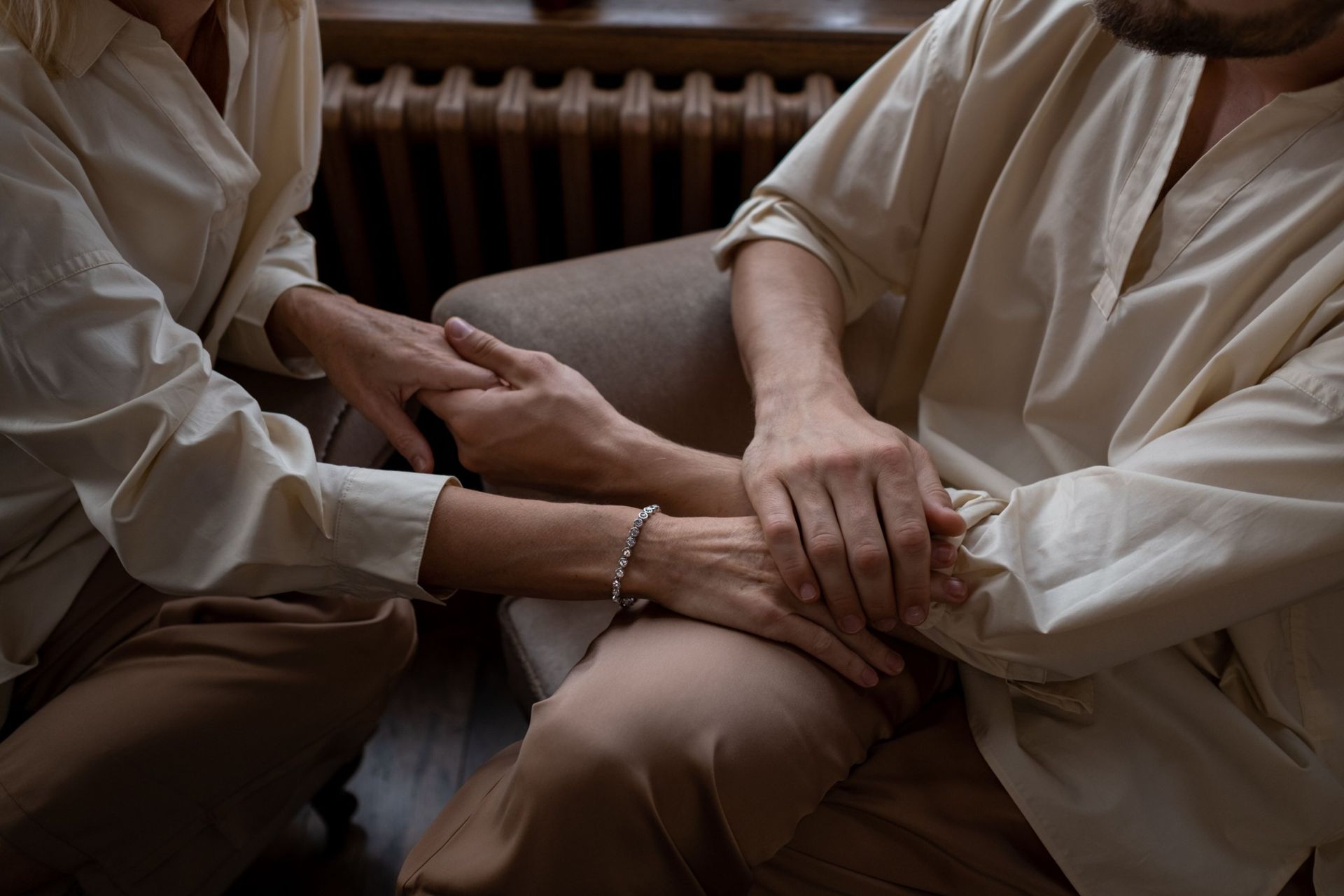 Two people holding hands in a quiet moment of comfort